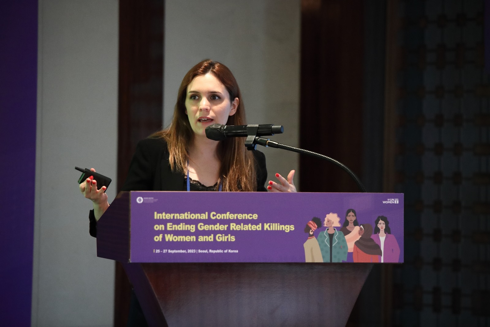 Cátia Pontedeira a intervir num púlpito durante uma conferência internacional